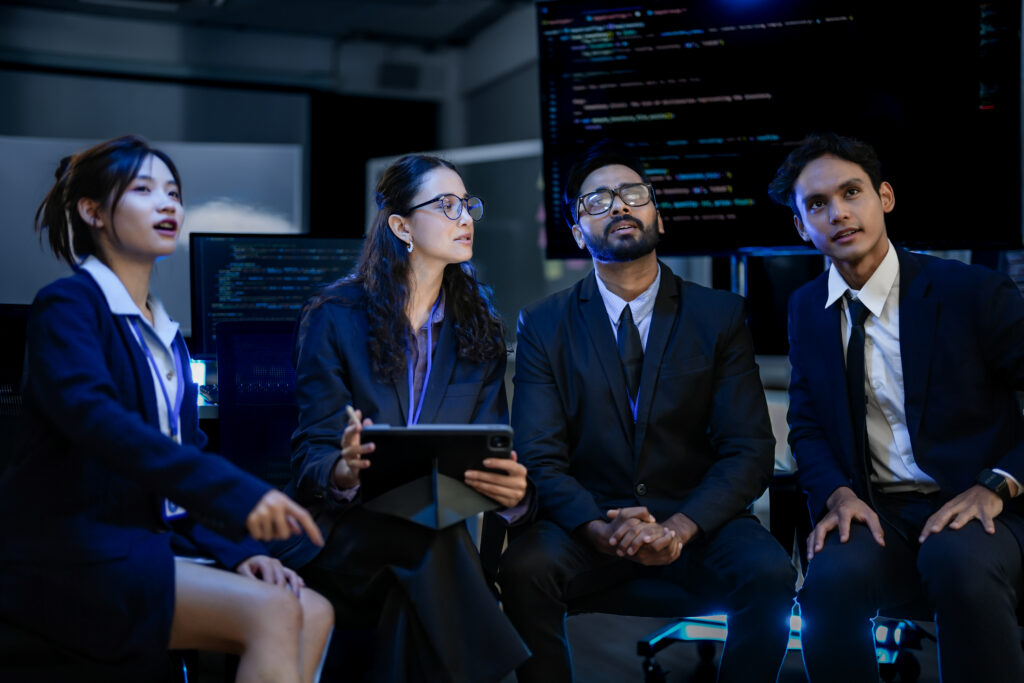 A diverse team of AI engineers collaborating during a late-night strategy and coding session.